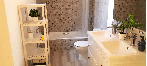 Tiled bathroom with bath and two basins